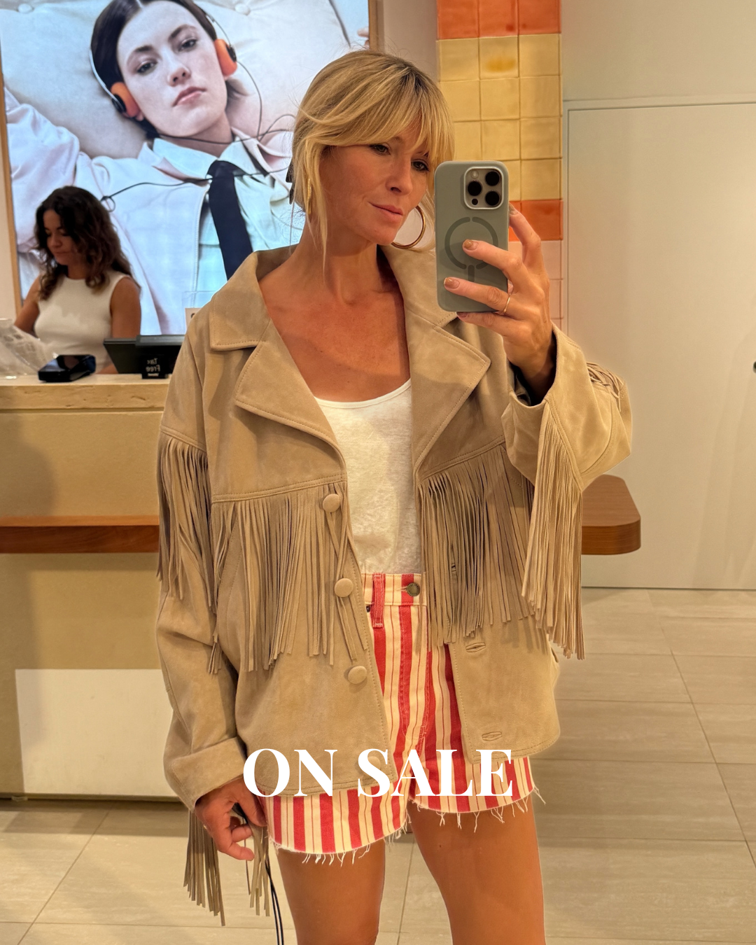 Trying on the fringed Sandro jacket with striped shorts