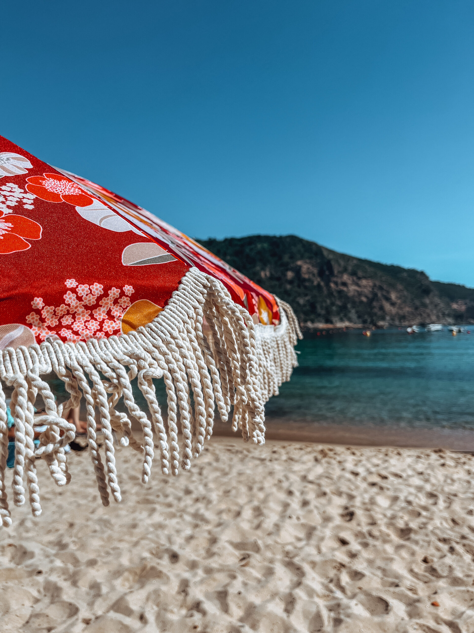 Costa Brava beach with a red fringed umbrella