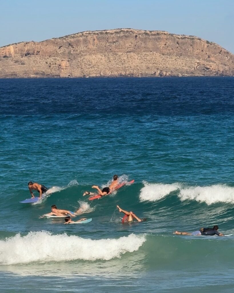 Surfers in the waves at Cala Nova beach