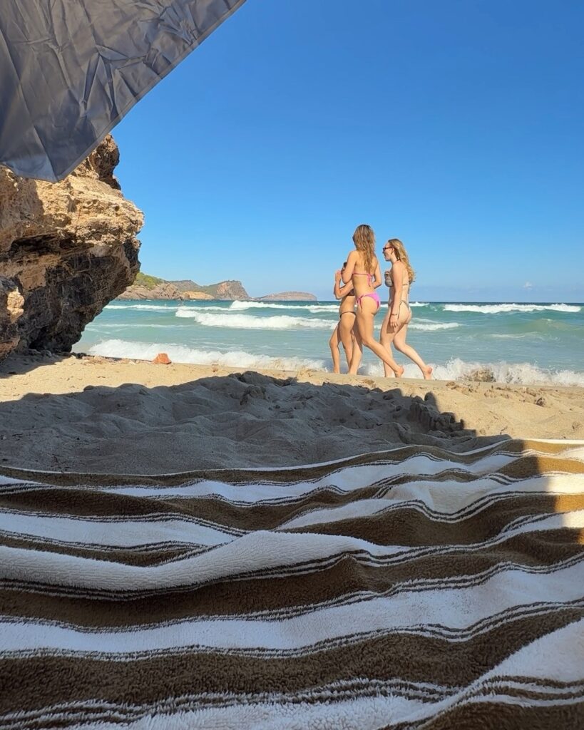 Cala Nova beach view from a striped towel