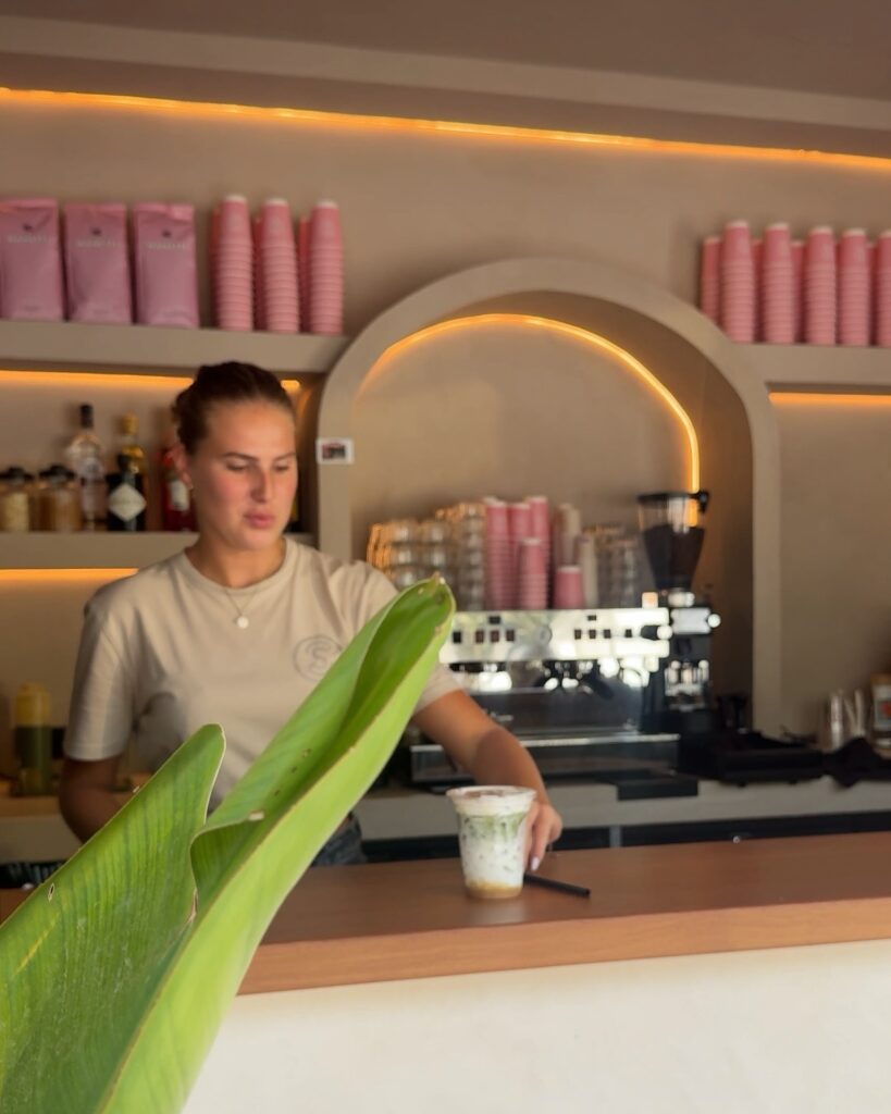 Barista at the pink counter of Stoop Café