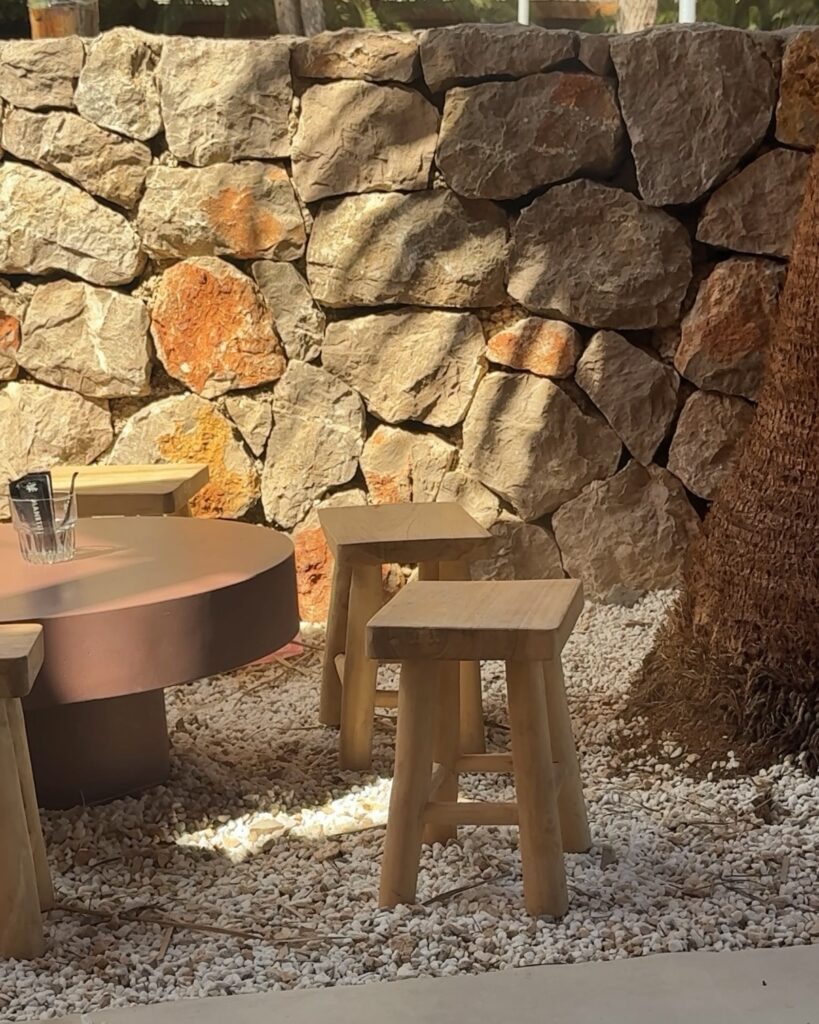 Stone wall and wooden stools on the terrace at Stoop Café